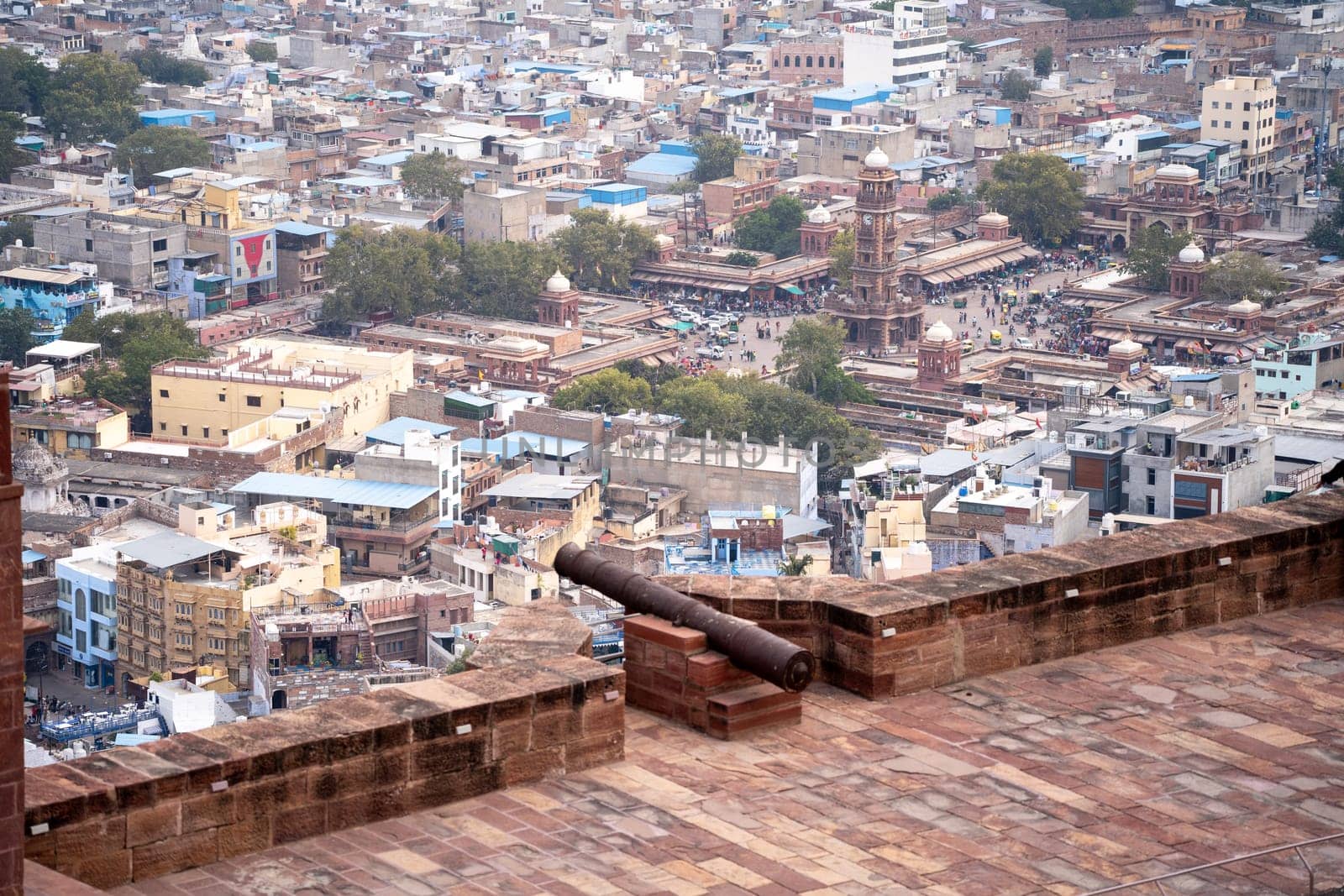 Ancient iron cannon set on the walls of a fort looking out over the city of jodhpur, jaipur, udaipur showing the defences of the ancient Rajput kings
