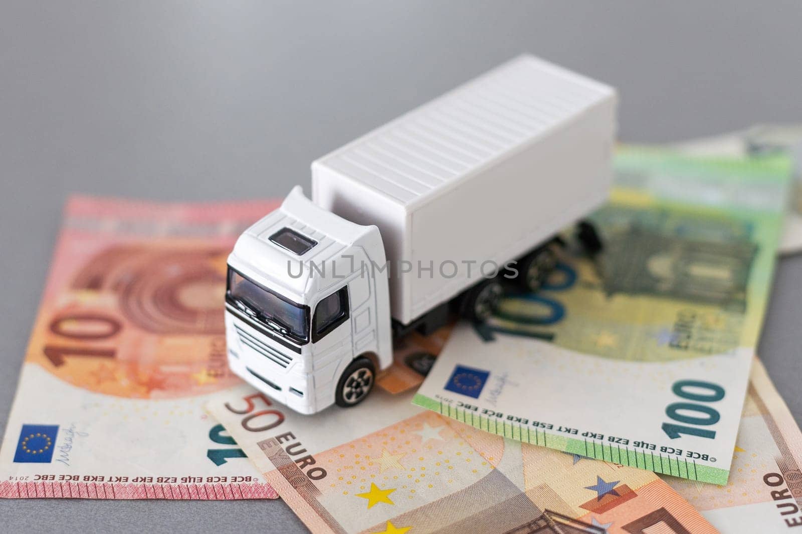 white toy truck on euro banknotes. concept for logistics, transportation and and finance by Andelov13