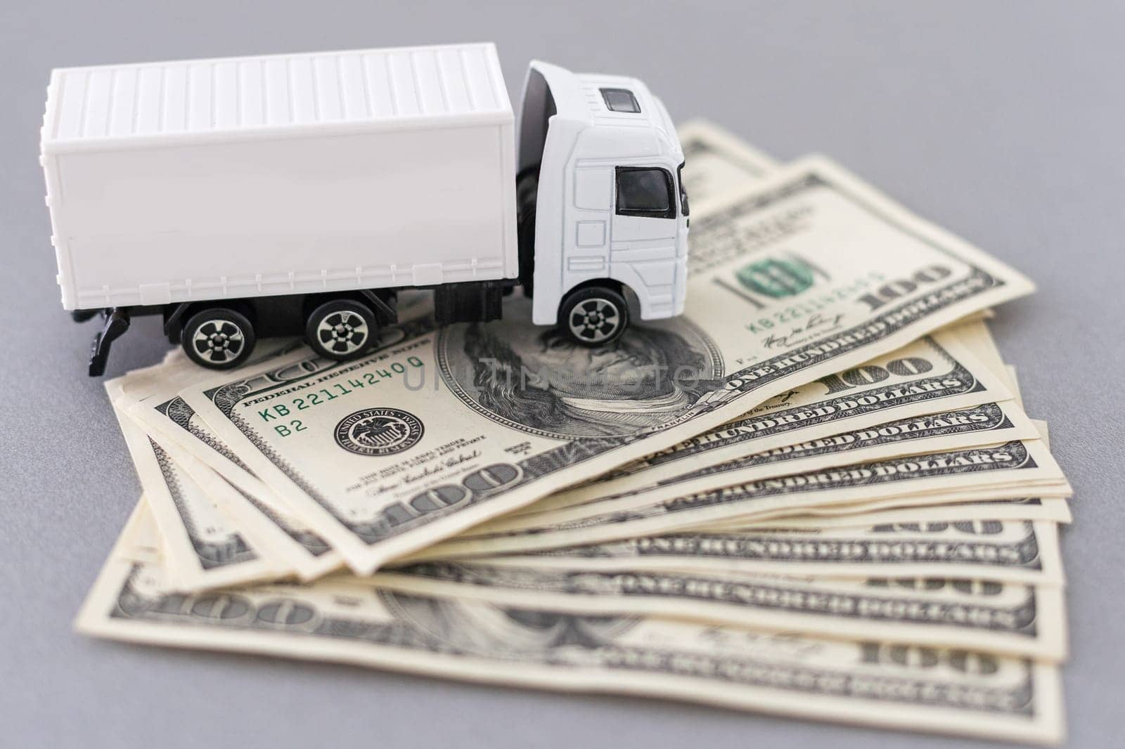 White toy truck lie on dollars, space for text. by Andelov13
