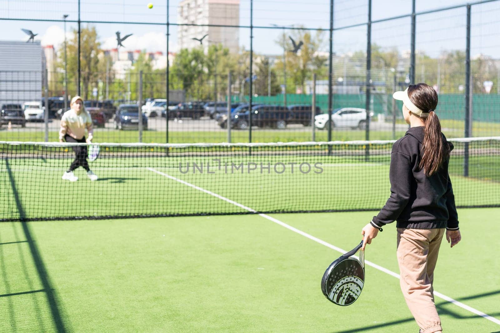 Young girls playing padel on a sunny day. High quality photo