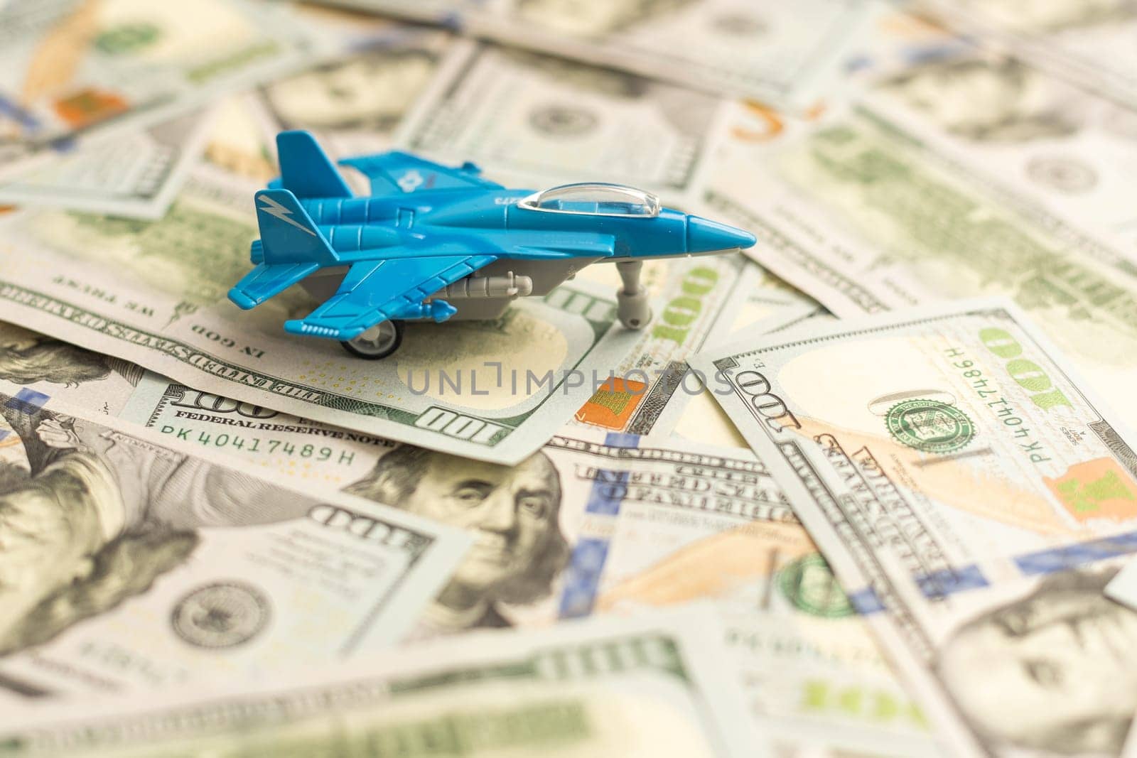 Background of one hundred dollar bills with model fighter airplane by Andelov13