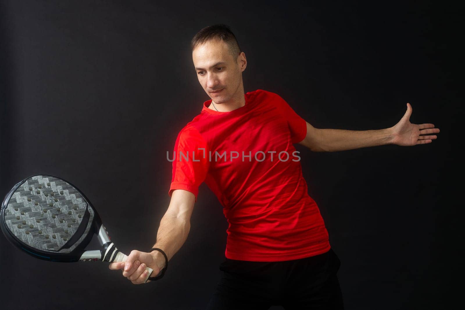 Professional monitor of paddel holding a black racket. Man paddel player playing a match in the open. High quality photo