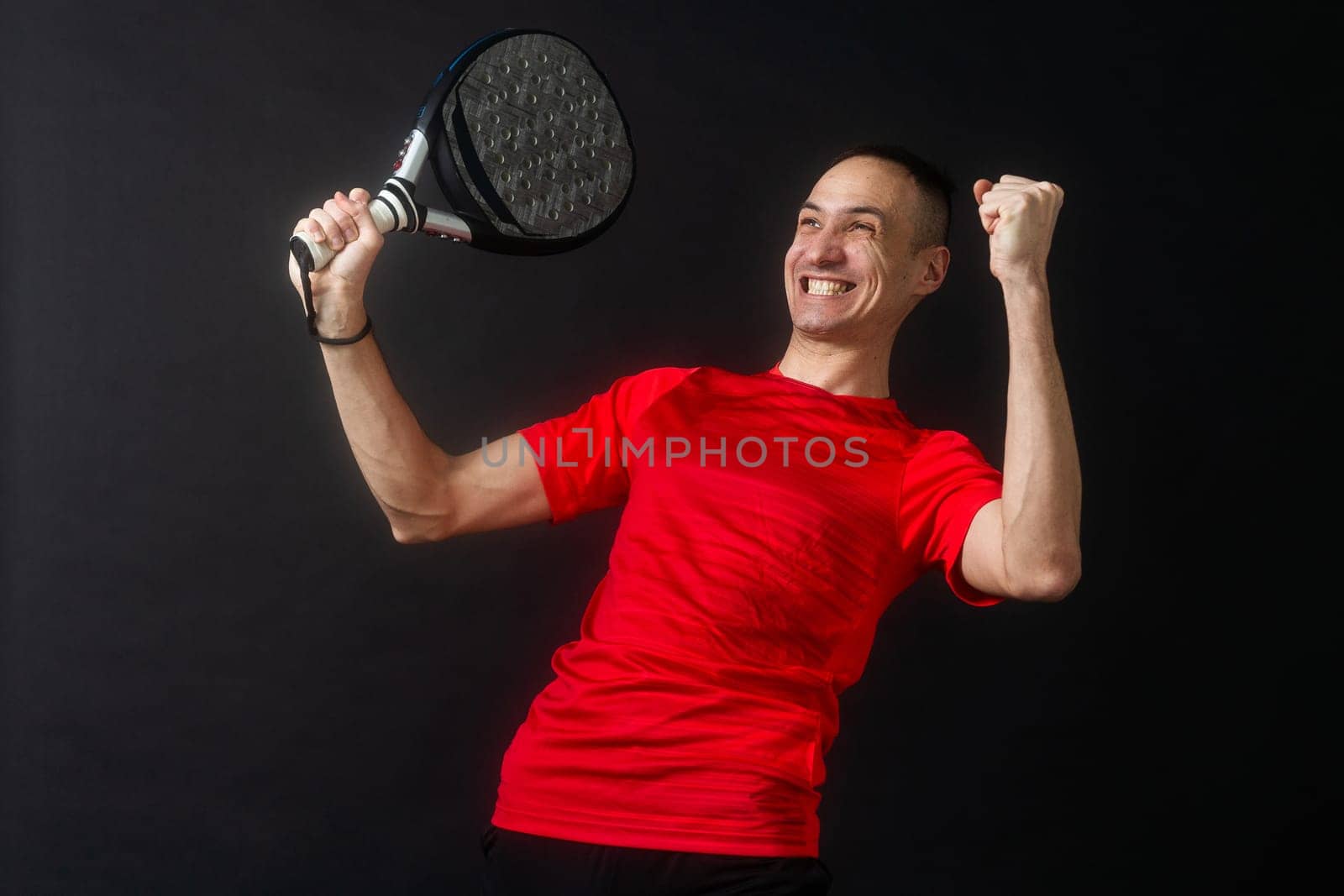 Professional monitor of paddel holding a black racket. Man paddel player playing a match. by Andelov13