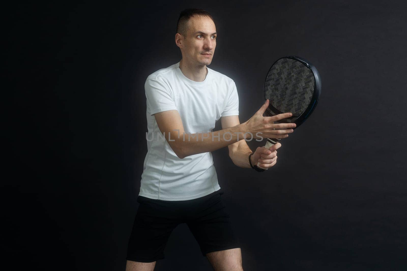 Beautiful man playing paddle tennis, racket in hand concentrated look. Young sporty boy ready for the match. Focused padel athlete ready to receive the ball. Sport, health, youth and leisure concept by Andelov13