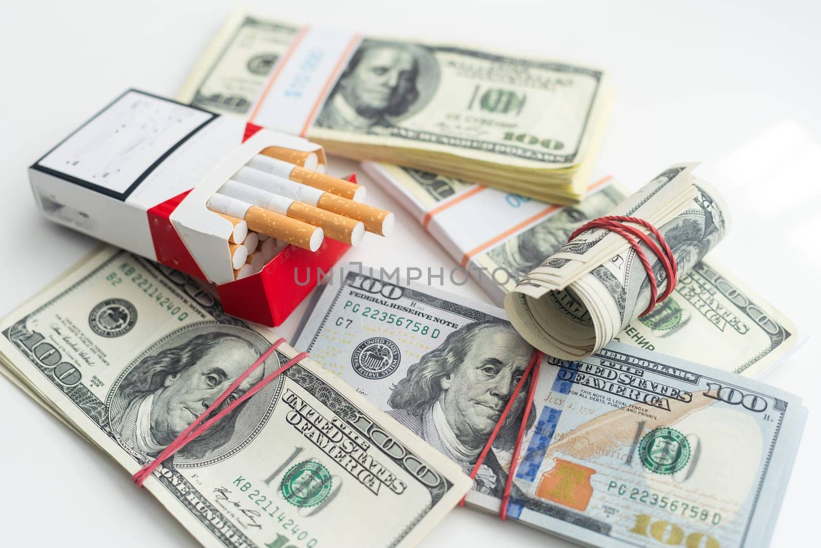 white cigarettes lying on the dollar bills. concept of financial cost of smoking. High quality photo