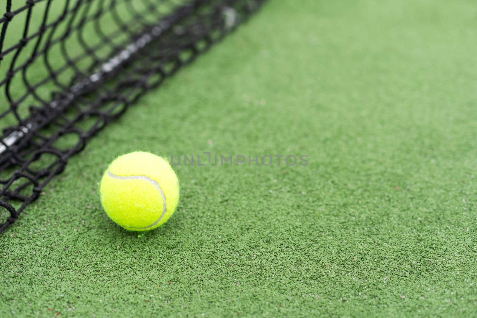 Tennis Ball on the Court against the Court Net. High quality photo