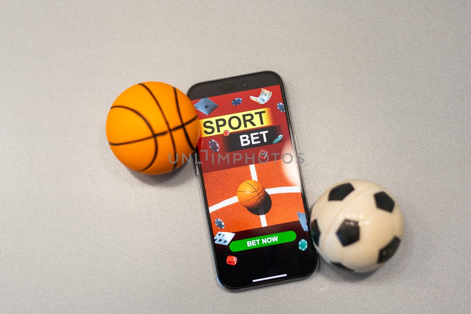 Sports betting website in a mobile phone screen, ball, money. High quality photo
