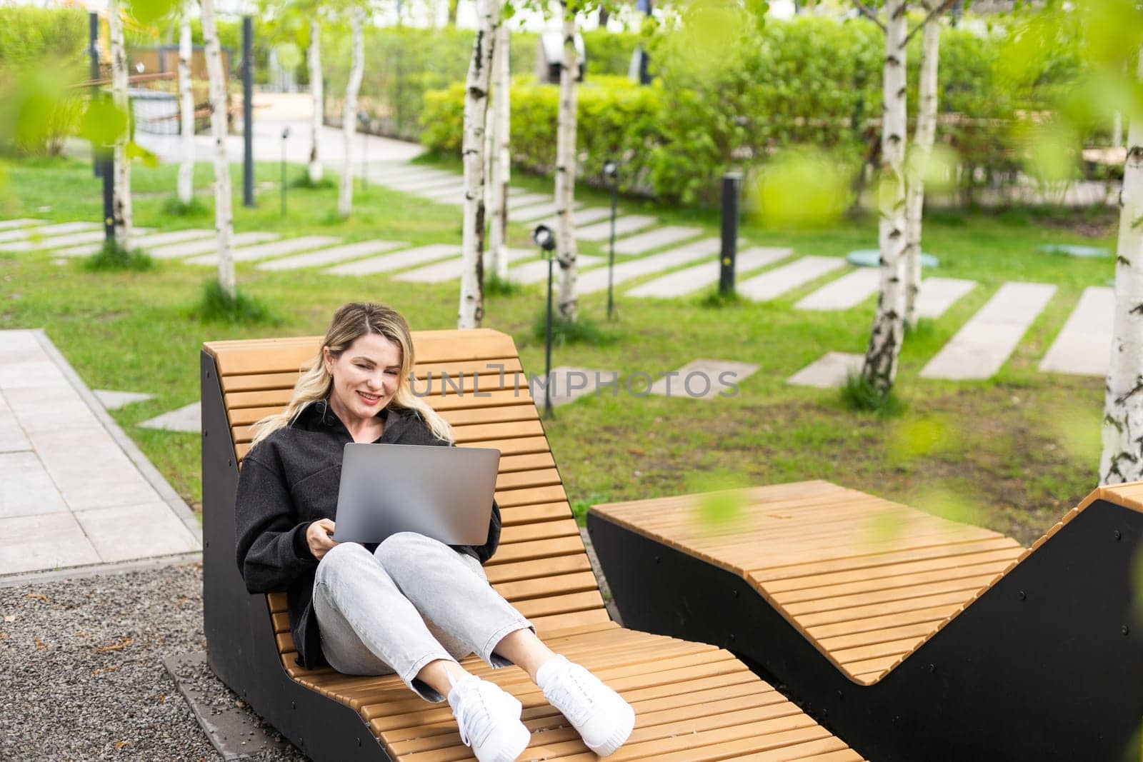 Young woman with laptop outside by Andelov13