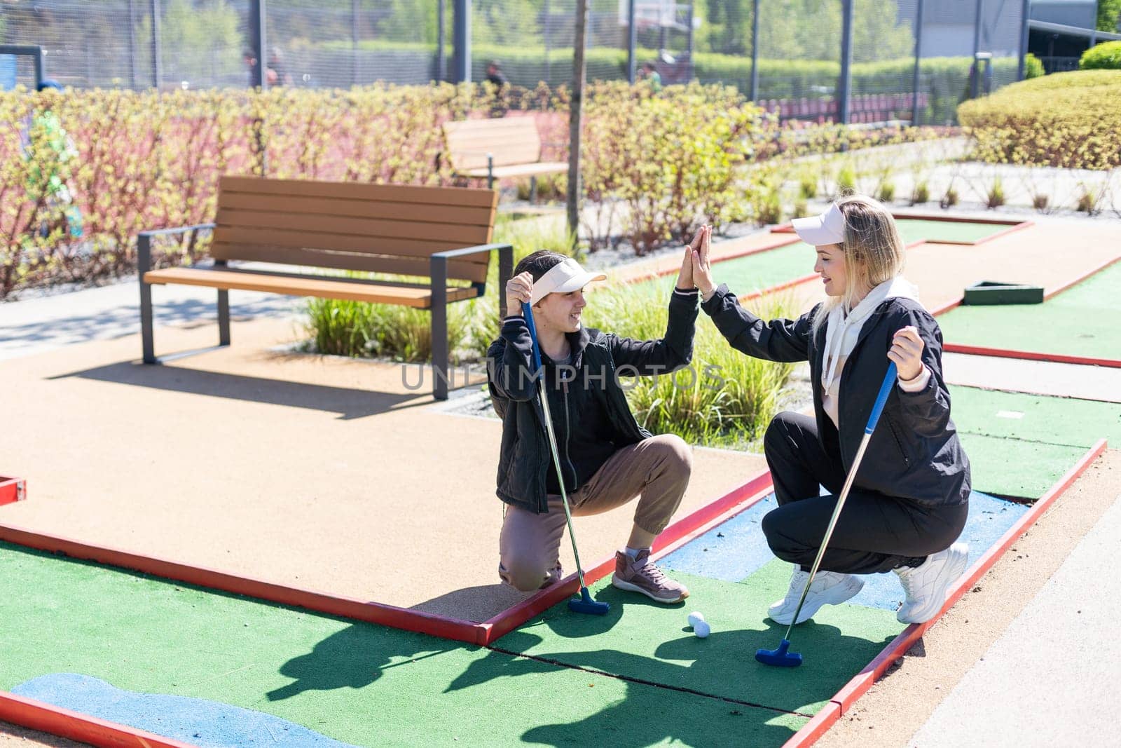 Family Time Playing Mini-Golf In The Summer. High quality photo