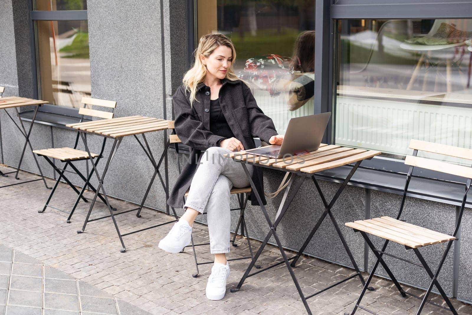 Young woman with laptop outside. High quality photo