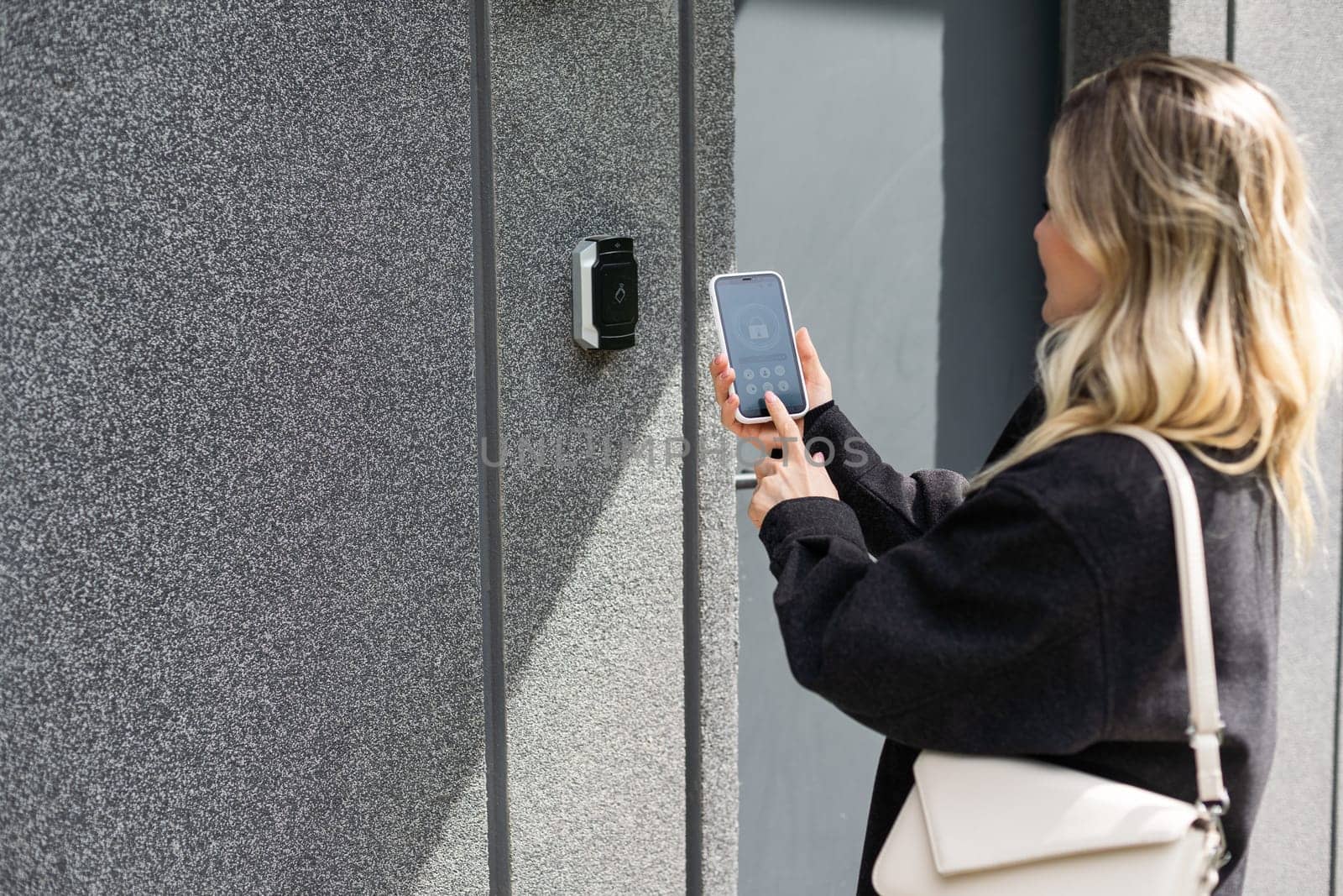 female entering secret key code for getting access and passing building using application on mobile phone, woman pressing buttons on control panel for disarming smart home system by Andelov13