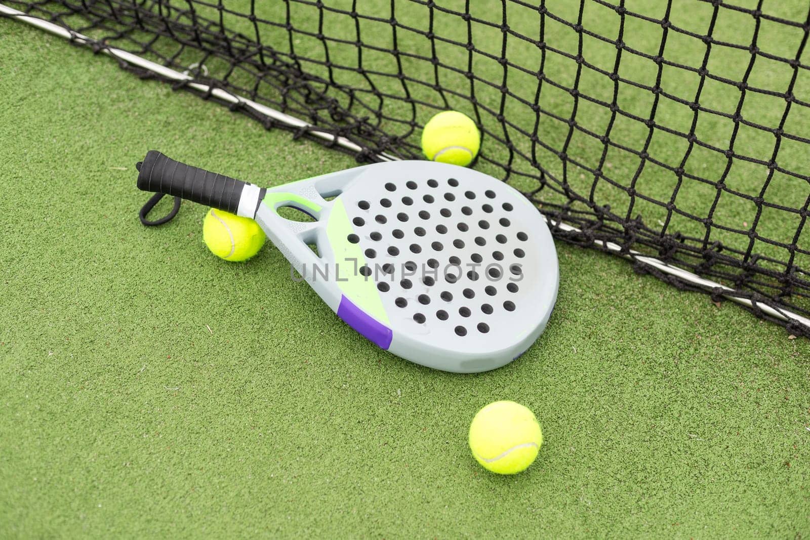 Paddle racket, next to the ball and on a carpet of the play area. High quality photo