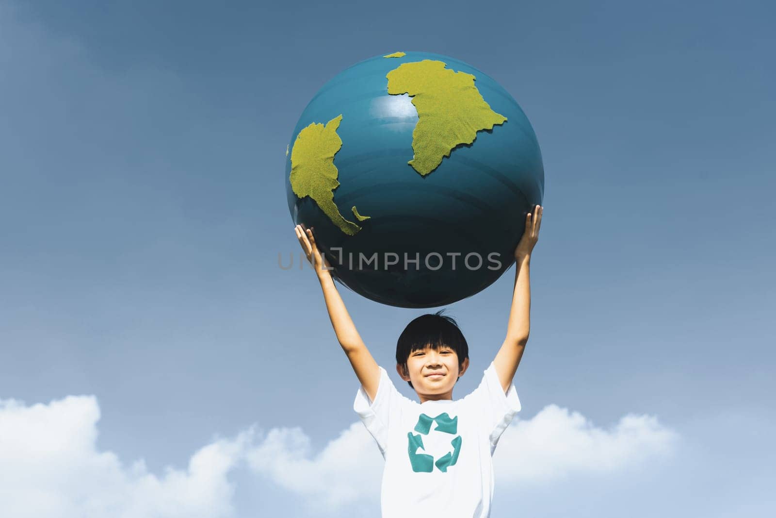 Young asian boy holding big planet Earth globe at sky and cloudscape background as Earth day to save this planet with ESG principle and environment friendly energy for brighter future. Gyre