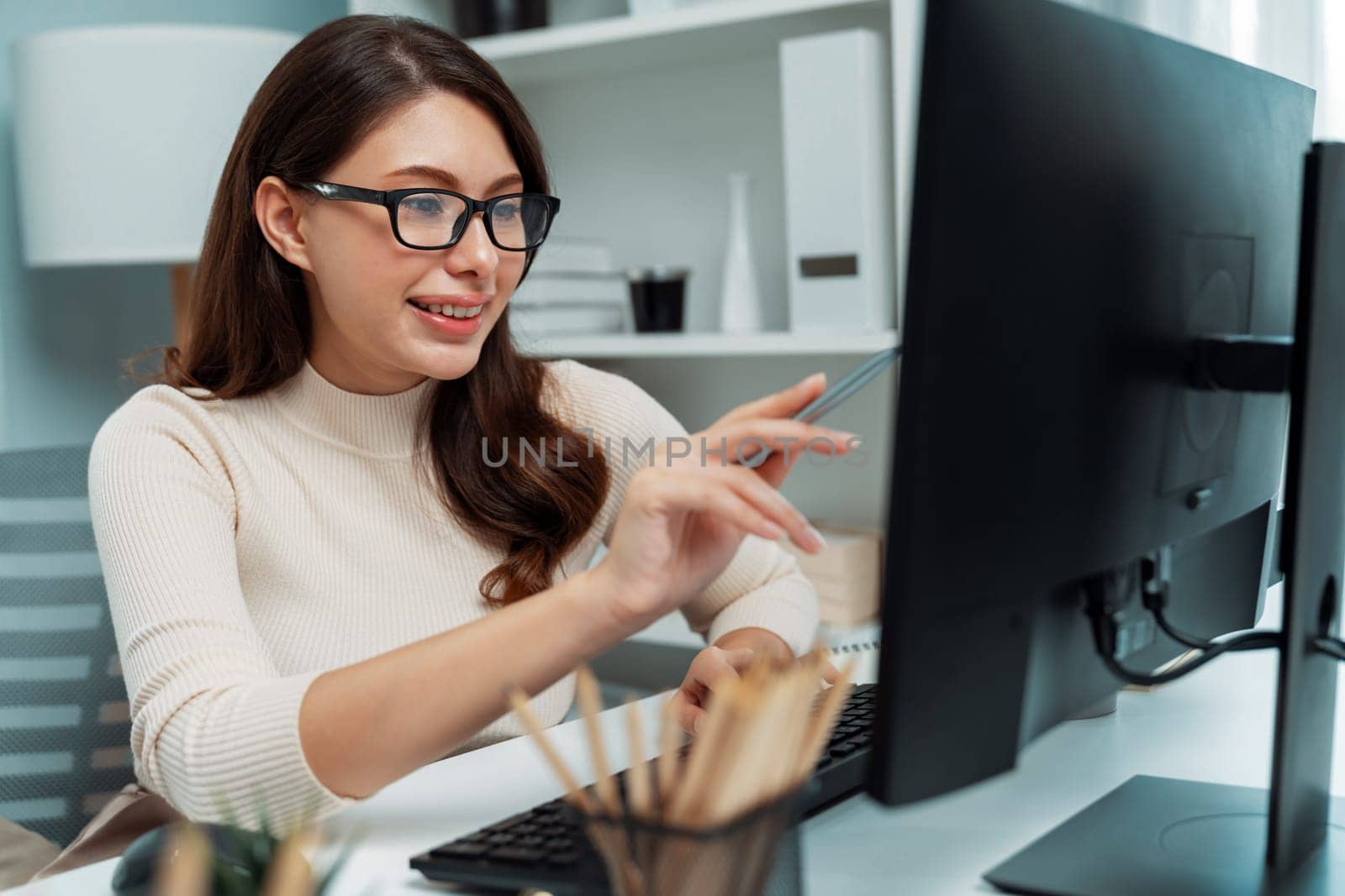 Casual outfit smiling beautiful businesswoman wearing glasses looking report on pc, analyzing to create marketing plan to analyze new customer target with update promotion at modern office. Postulate.