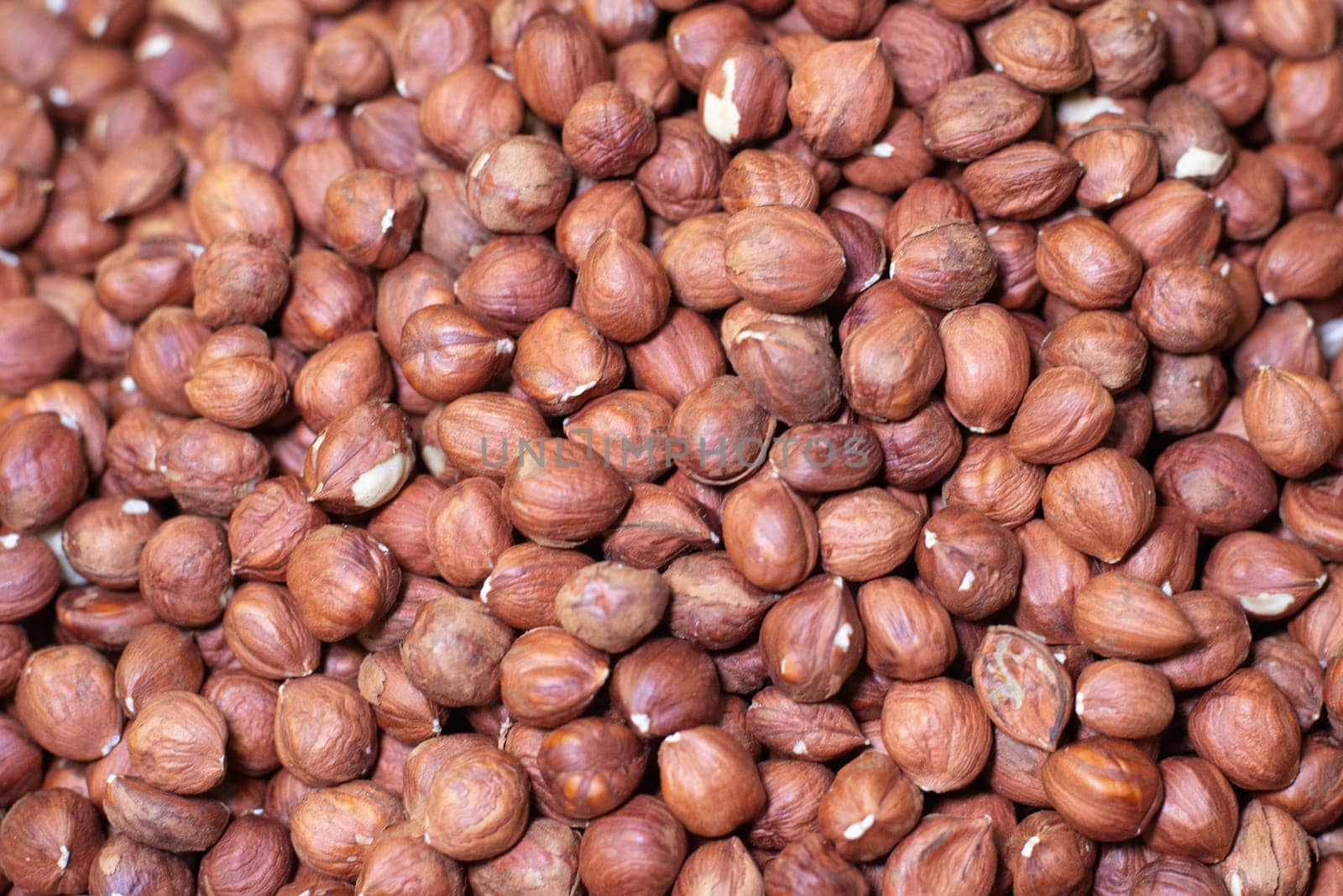 Background of kernels of hazelnut, warm brown shades. A natural source of strength, protein and vitamins. A useful product with diet and special nutrition. High quality photo