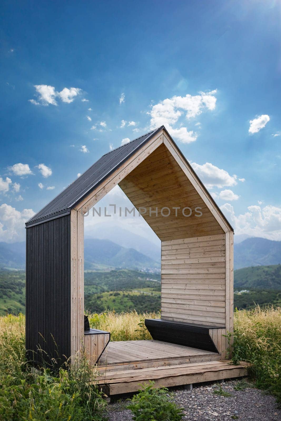Wooden gazebo with benches for romantic weekend dating in summer nature. copy space, vertical