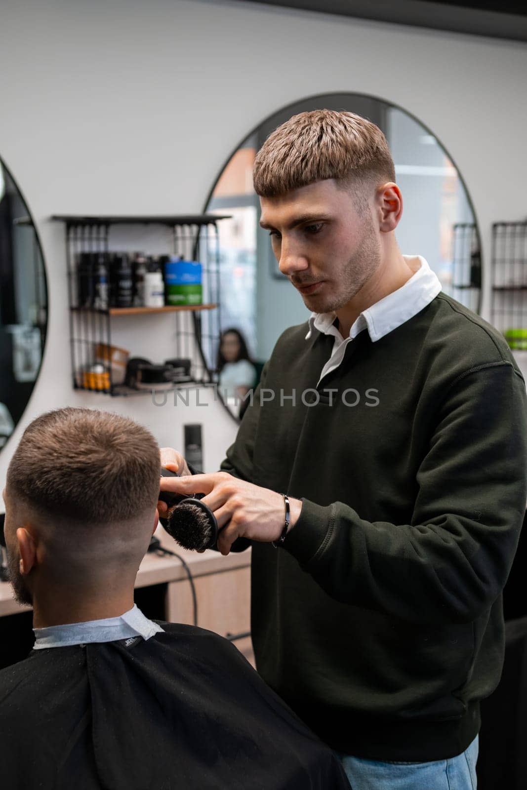 Master trims client hair with professional tool in shop by vladimka