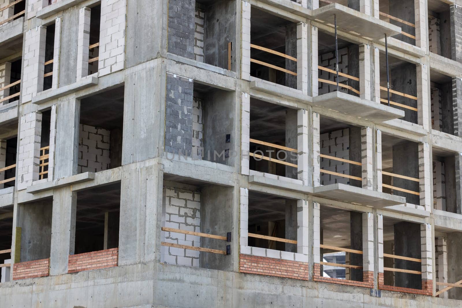 A tower block under construction, featuring a facade with numerous windows and balconies. The property is being built using composite materials, designed for urban living in a condominium