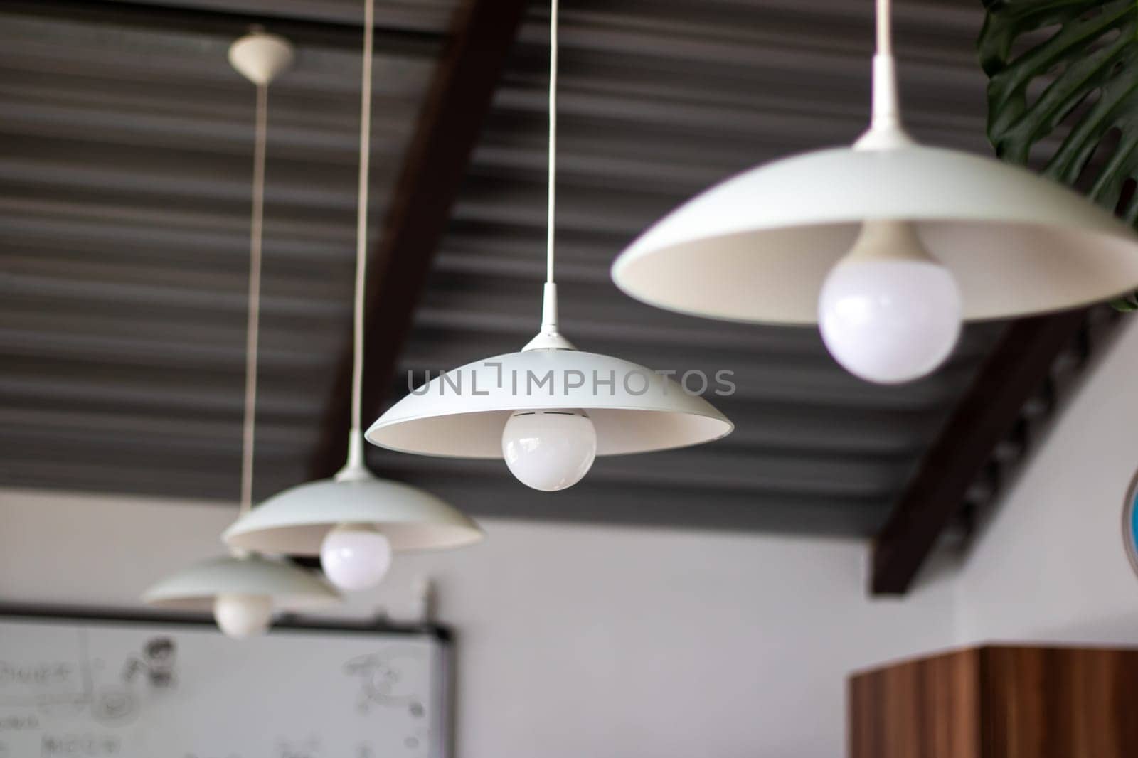 Three elegant pendant lights, white in color, dangle gracefully from the ceiling, adding a touch of sophistication to the room