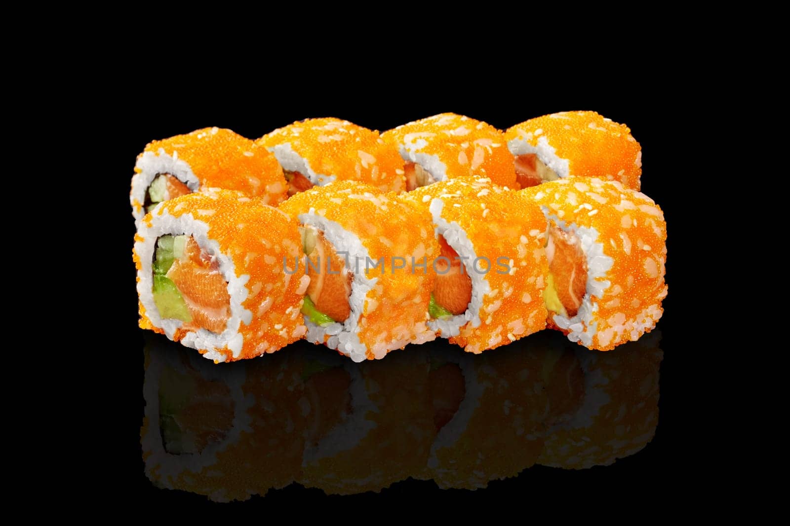 Classic California rolls with raw salmon, avocado and cucumbers coated with vibrant orange tobiko roe presented against reflective black background. Sushi bar menu