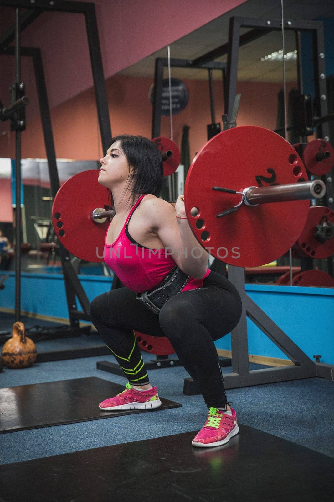 Bila Tserkva, Ukraine, October 15,2016: Attractive girl squats with a barbell in the gym