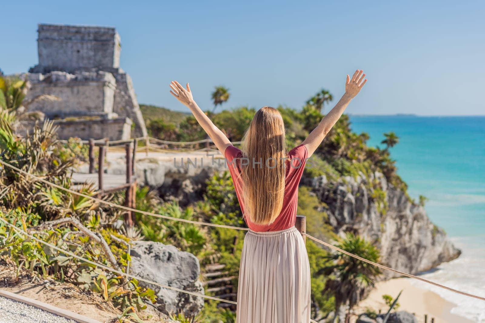 Woman tourist enjoying the view Pre-Columbian Mayan walled city of Tulum, Quintana Roo, Mexico, North America, Tulum, Mexico. El Castillo - castle the Mayan city of Tulum main temple.