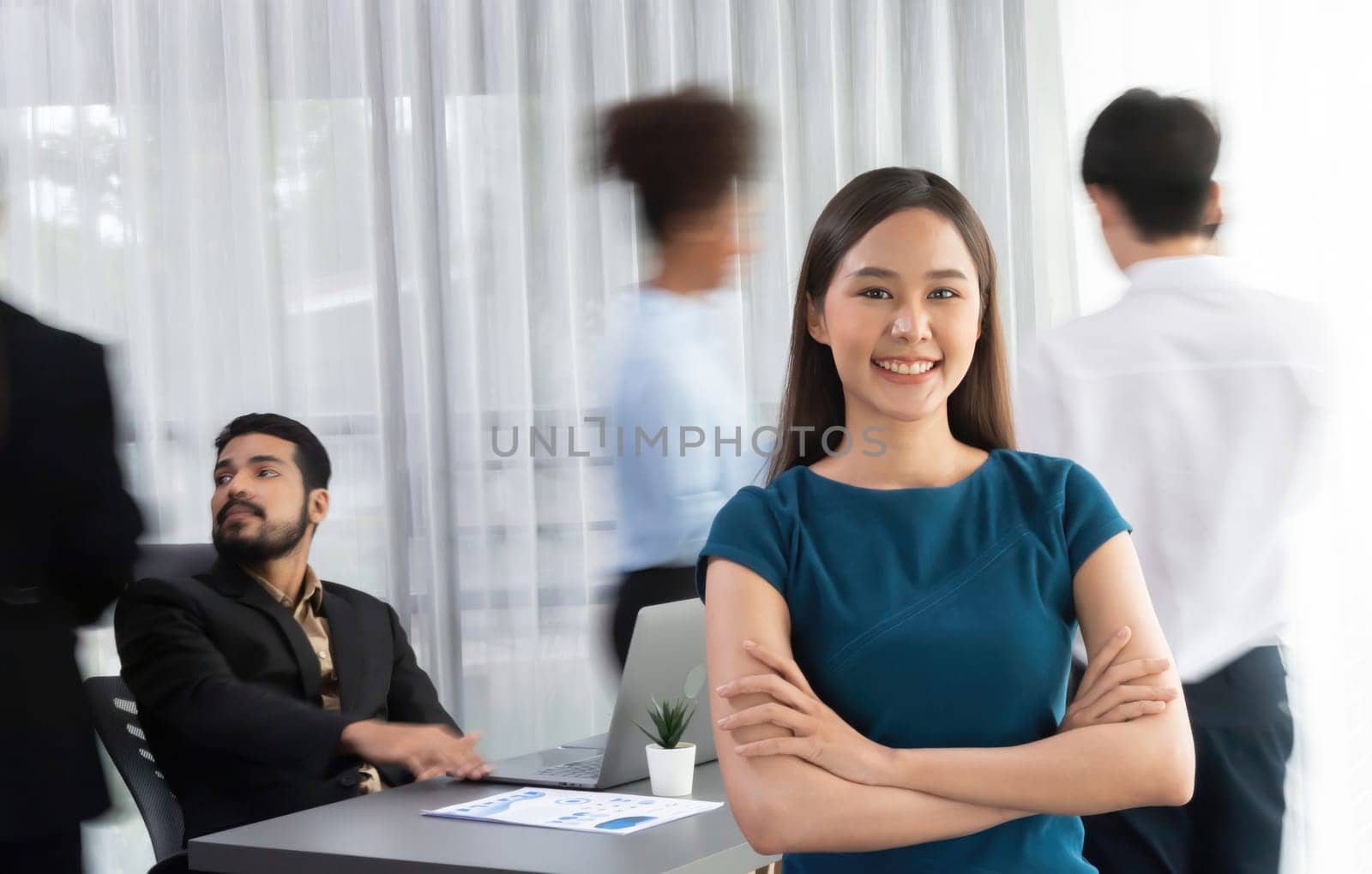 Young Asian businesswoman portrait poses confidently with diverse coworkers in busy meeting room in motion blurred background. Multicultural team works together for business success. Concord