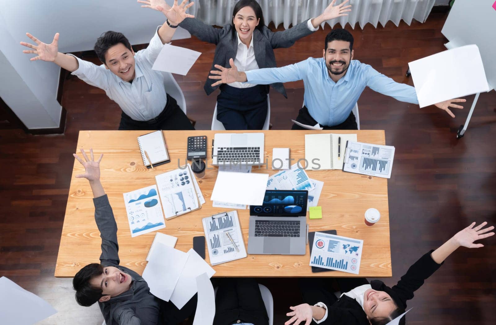 Top view office worker celebrate in meeting room, throwing paperwork in the air. Excitement and freedom expression from business people throw analysis financial paper in celebratory gesture. Concord
