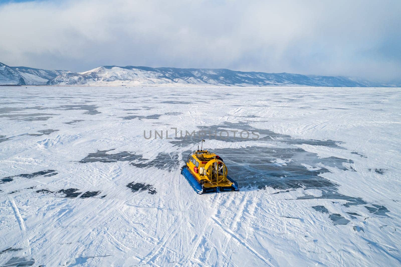 Aerial view on a hovercraft parked on the beautiful cracked ice of the lake Baikal. Winter Baikal, frozen lake. Amazing winter landscape. by Busker