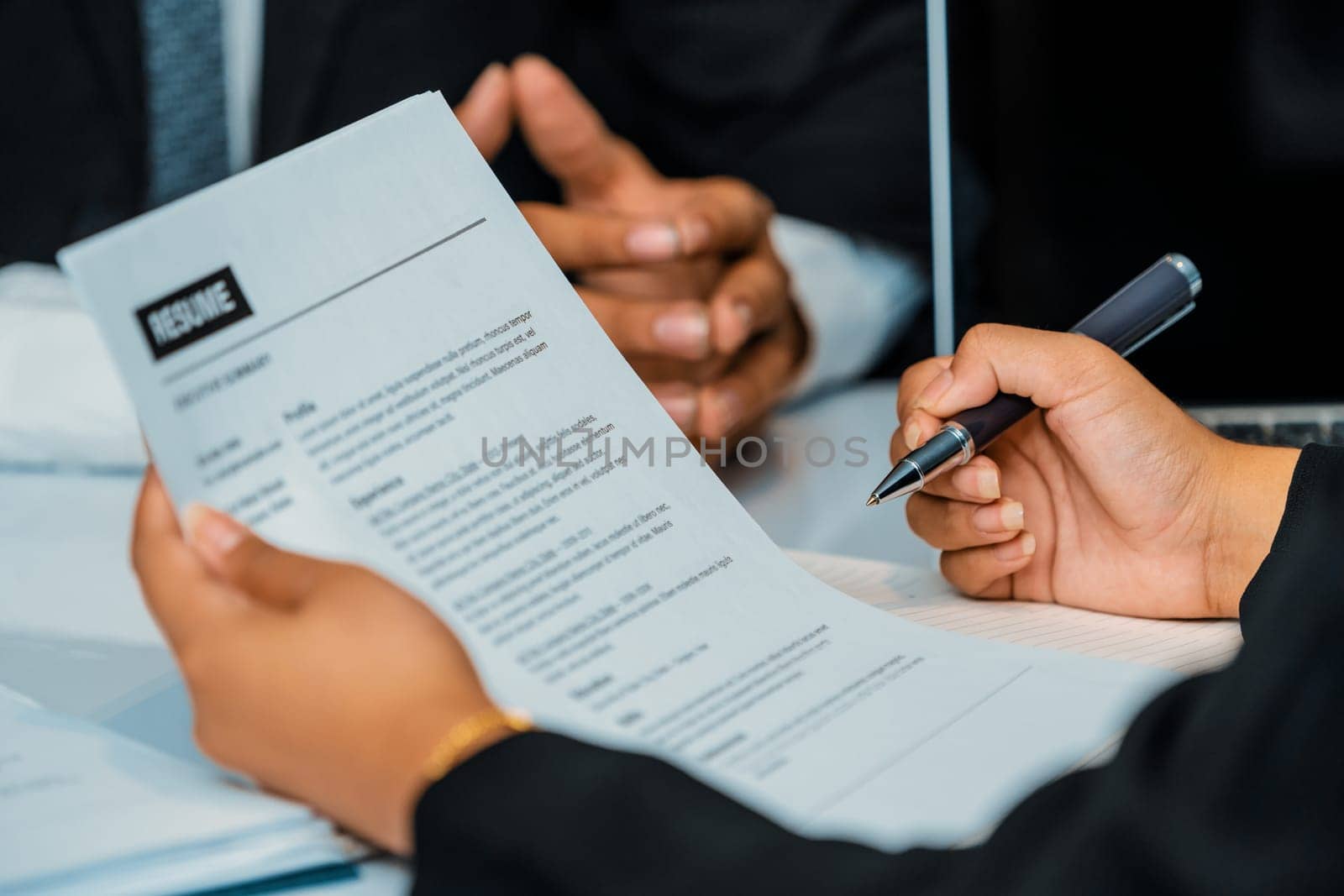 Human resources department manager reads CV resume document of an employee candidate at interview room. Job application, recruit and labor hiring concept. uds
