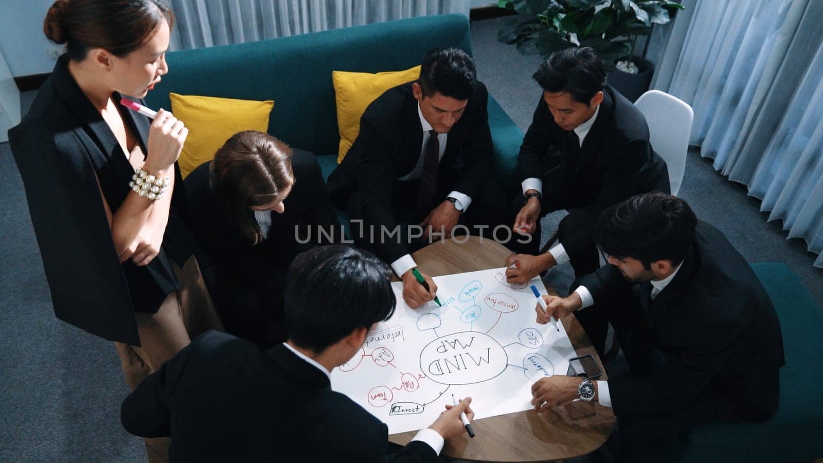 Top view of skilled diverse business people planning project by using mind map to brainstorm marketing idea. Closeup of smart start up team working together to draw creative mind map. Directorate.