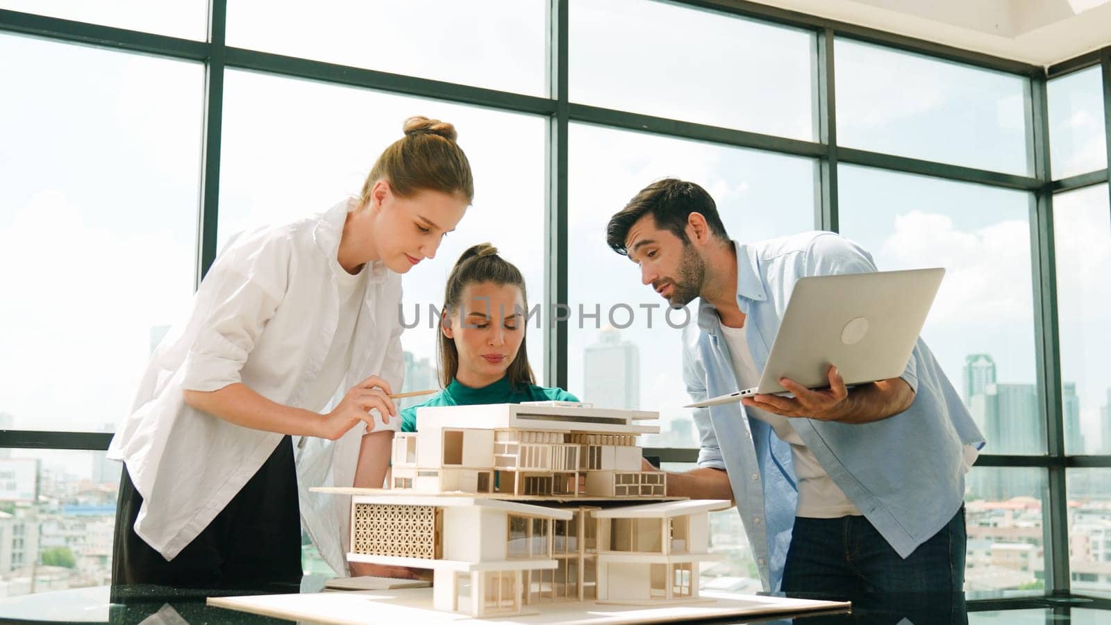 Smart architect team discussion about house design while handsome male worker present idea by using laptop. Group of professional engineer sharing, brainstorming design. Business design. Tracery