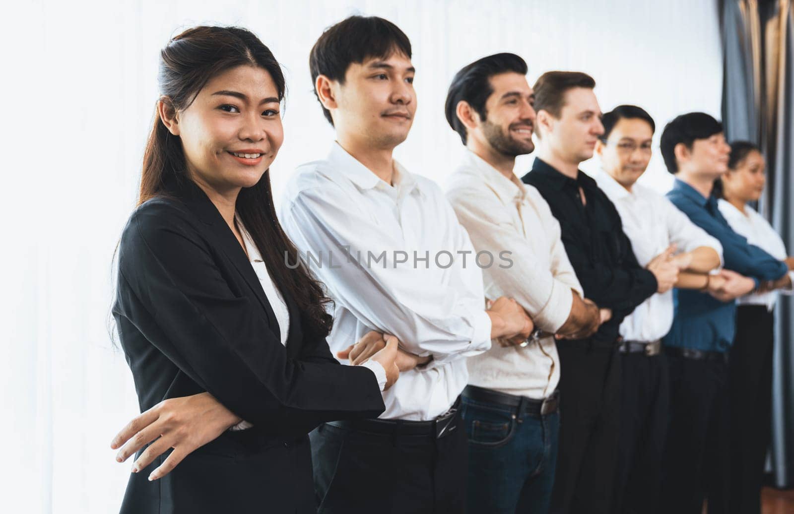 Business team standing, join and link hand together in line symbolize successful business partnership and professional synergy with diverse culture group people cooperation. Prudent