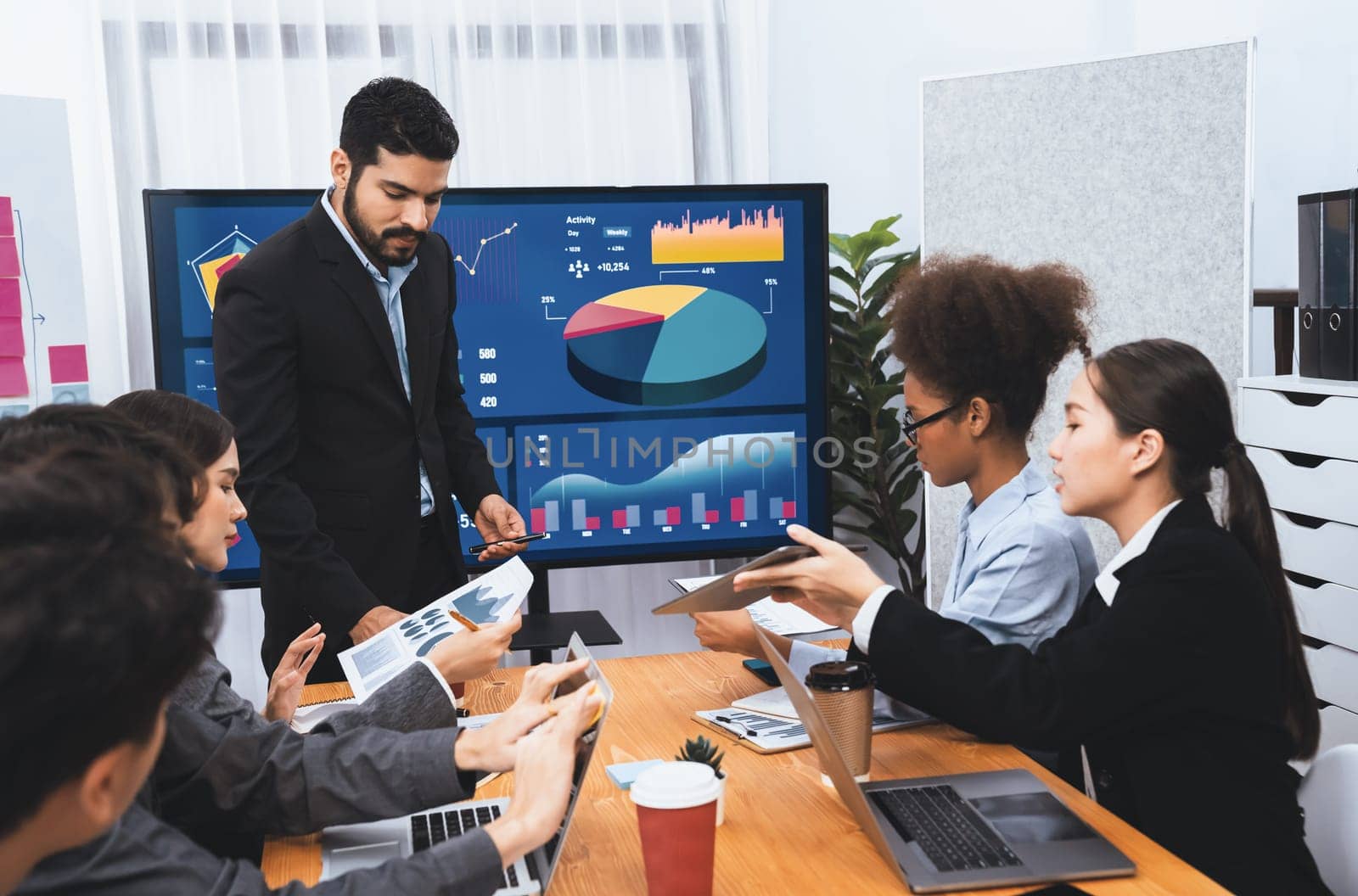 Businessman presenting data analysis dashboard display on TV screen in modern meeting for marketing strategy. Business presentation with group of business people in conference room. Concord