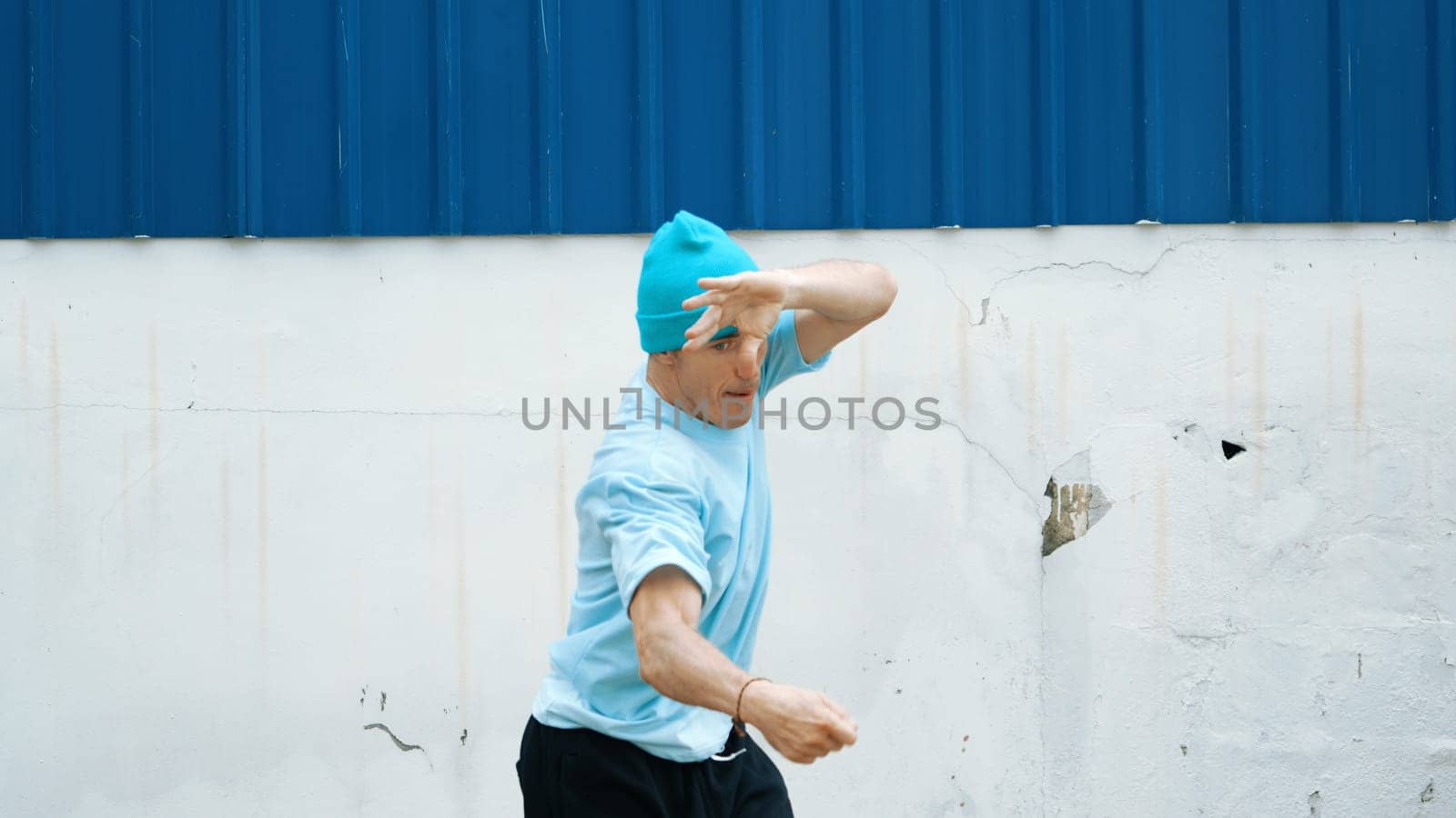 Motion shots of youthful hipster moving in lively groove at street. Caucasian break dance choreographer dancing in hip hop style. Energetic dancer perform b-boy dance. Outdoor sport 2024. Endeavor.