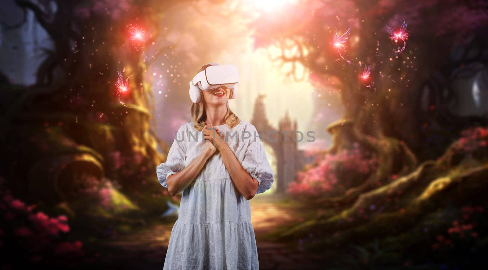 Happy girl enjoy looking at fantasy view hologram in VR glasses while connect at metaverse or visual reality world. Caucasian woman with white pajamas while standing at magical forest. Contraption.