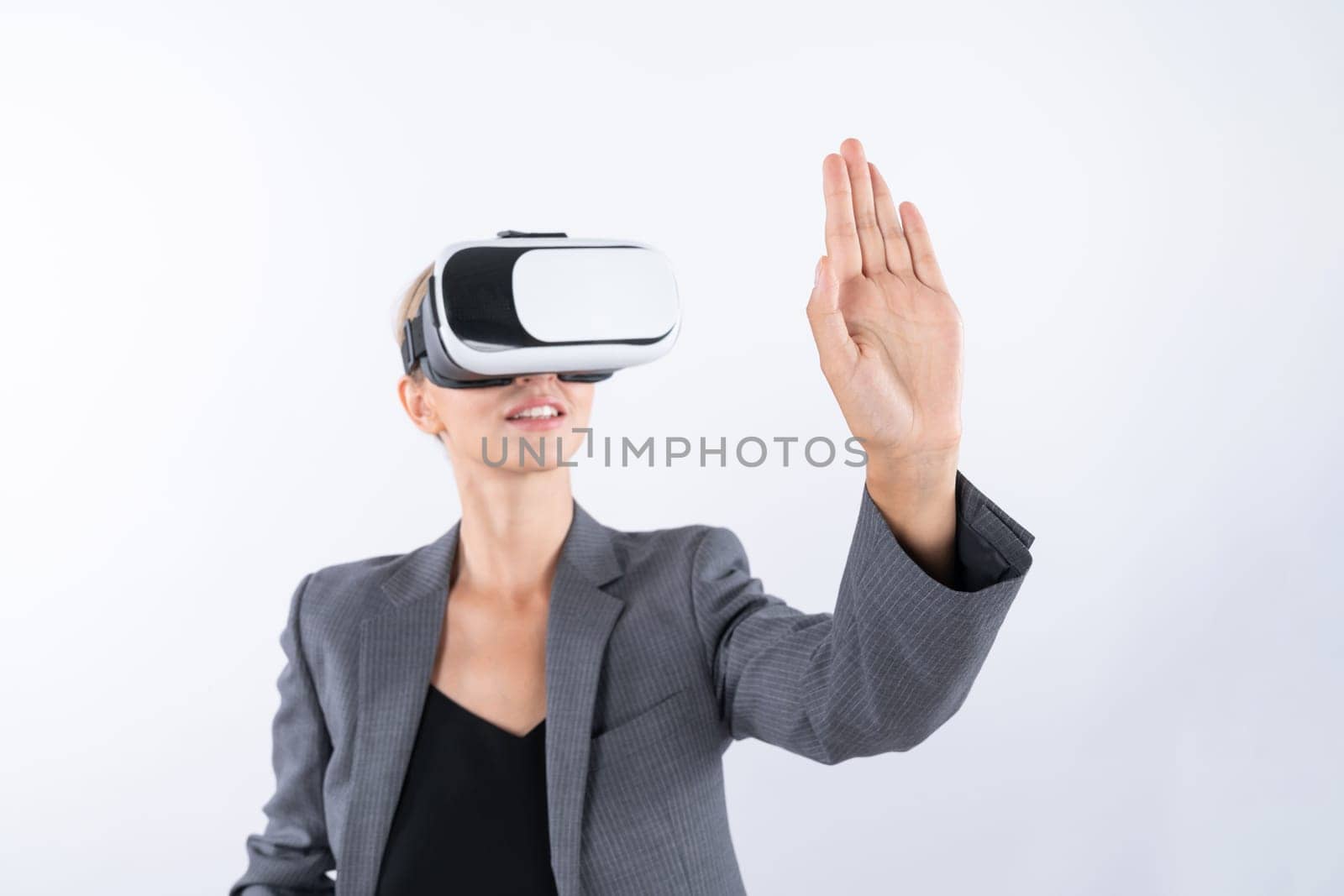 Smart business woman touching something while look though VR glass. Skilled project manager wearing suit and innovation technology visual reality goggles for connecting with metaverse. Contraption.
