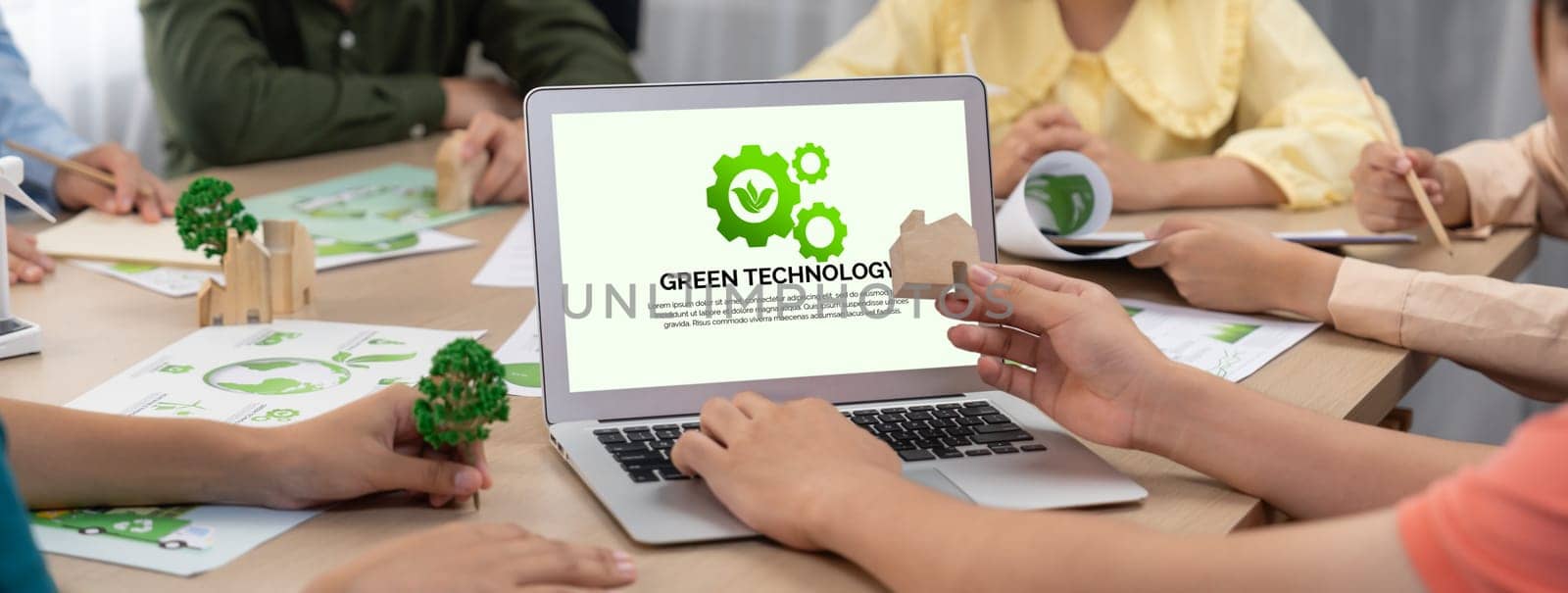 Green technology logo displayed on green business laptop while business team presenting green design to customer. ESG environment social governance and Eco conservative concept. Closeup. Delineation