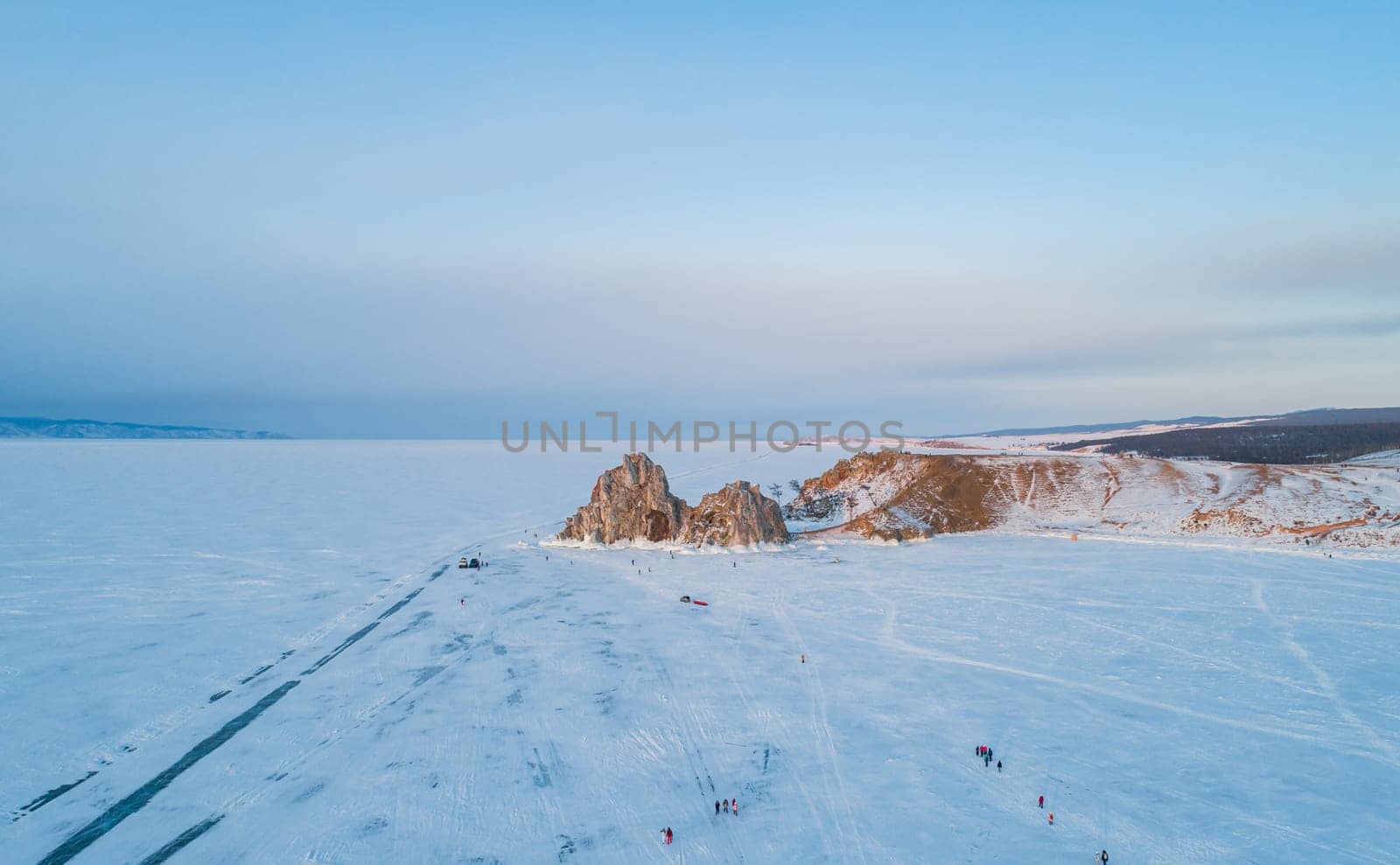 Aerial shot of Shamanka rock and Cape Burkhan on Olkhon. Beautiful view on frozen Baikal. Panoramic winter landscape. Popular touristic destination by Busker