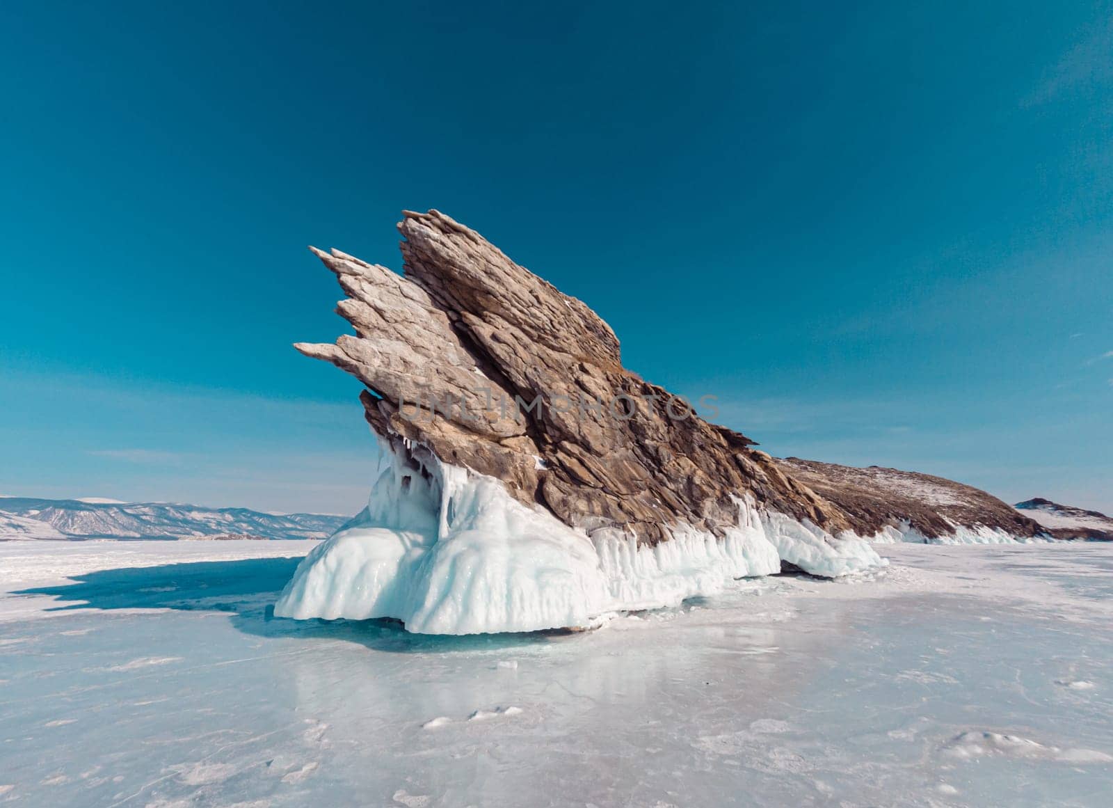 Ogoy island on winter Baikal lake. Winter scenery of Dragon Tail Rock on Ogoy island at Lake Baikal.