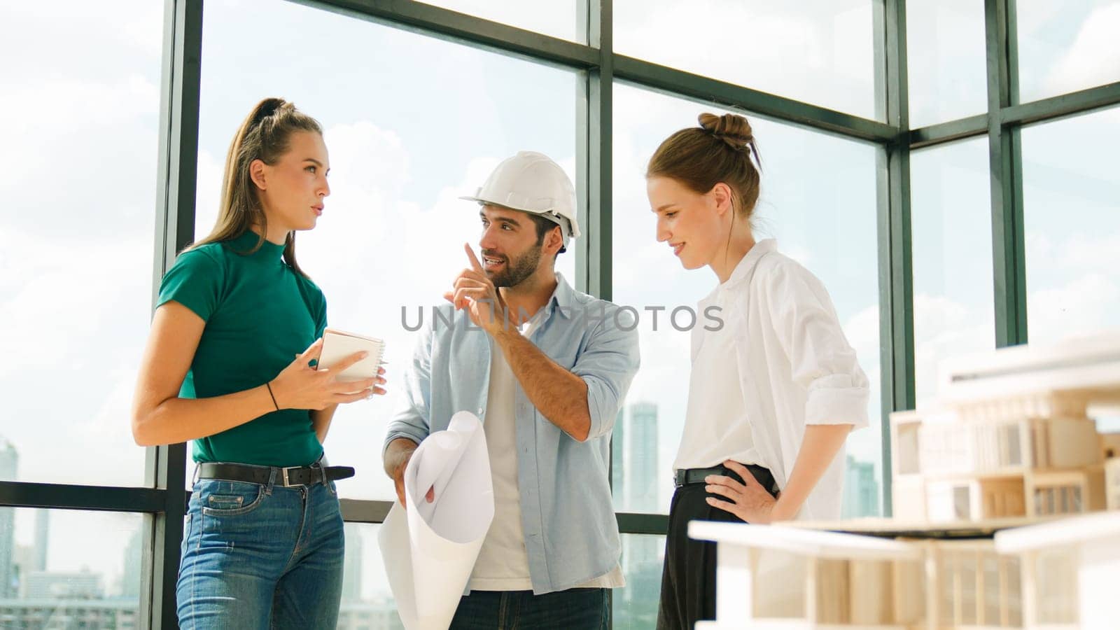 Group of smart architect engineer hold project plan while brainstorming idea about building structure. Manager team discuss about building construction while standing near with city view. Tracery