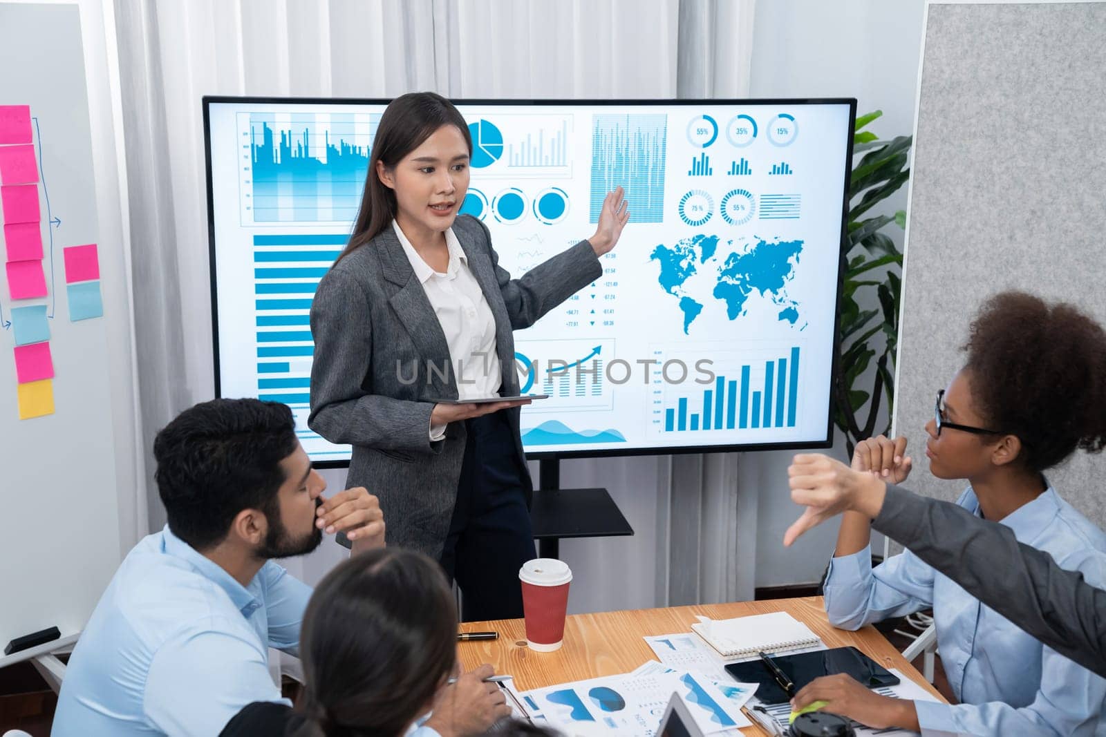 Young Asian businesswoman presenting data analysis dashboard on TV screen receive negative feedback from audience or colleague on meeting. Struggling with business presentation challenge. Concord