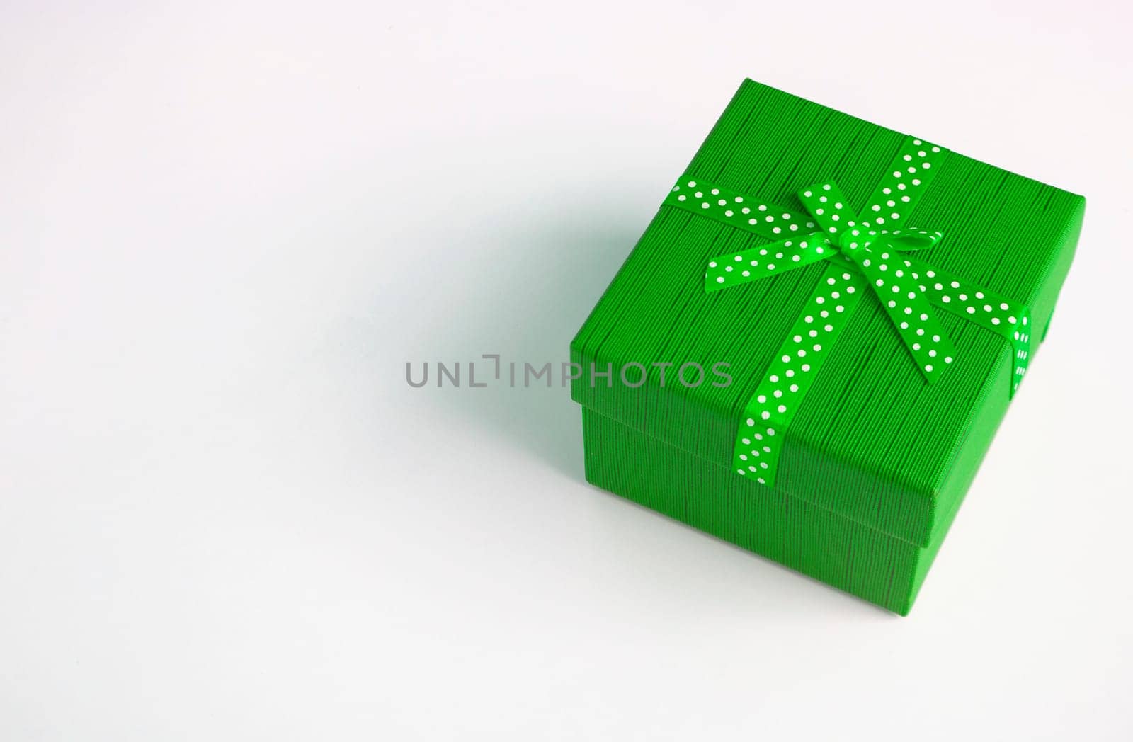 Green present on white background with customizable space for text. Copy space and celebration.