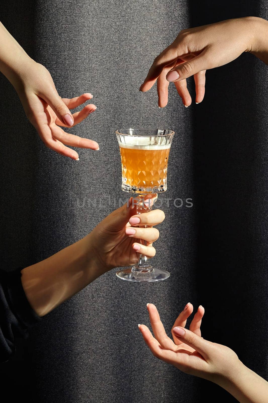 Female hands hovering around crystal glass of whiskey sour by nazarovsergey