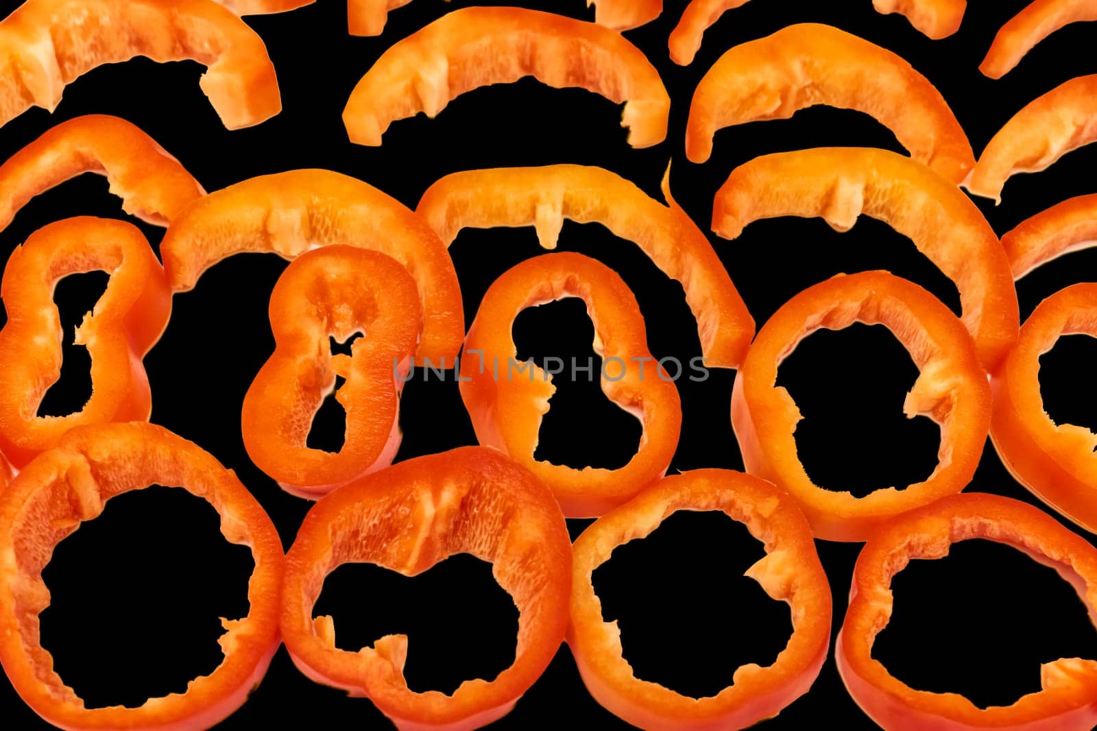 Red sweet ripe pepper cut into circles,slices on black by jovani68