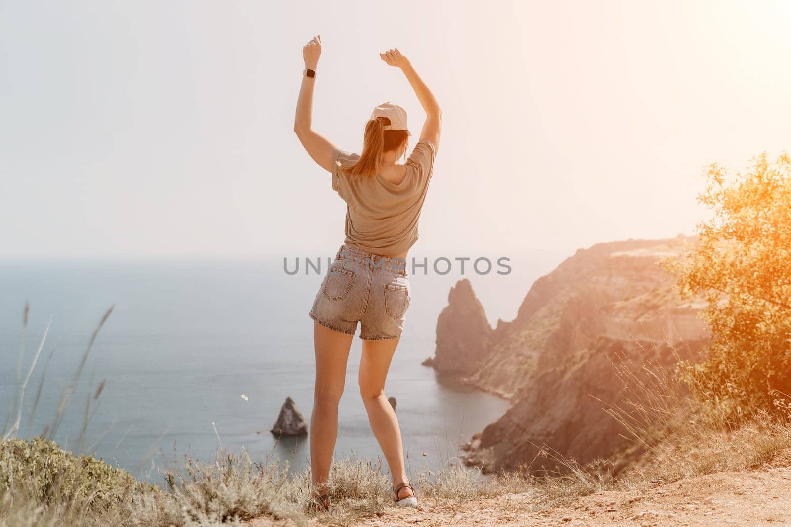 Woman travel sea. Happy carefree sensual woman with long hair in black swimwear posing at sunset beach. Silhouette of young beautiful playful positive woman outdoor. Summer vacation and trip concept