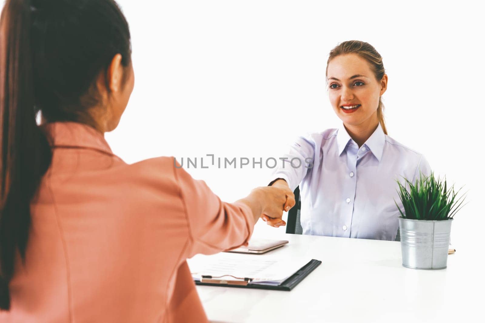 Two young business women in meeting at office table for job application and business agreement. Recruitment and human resources concept. uds