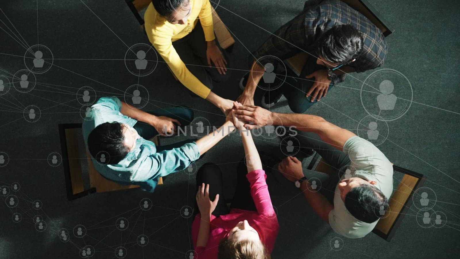Top aerial view of business people putting hands together to celebrate successful project while sitting chair circle with global networking communication holographic and global connection. Symposium.