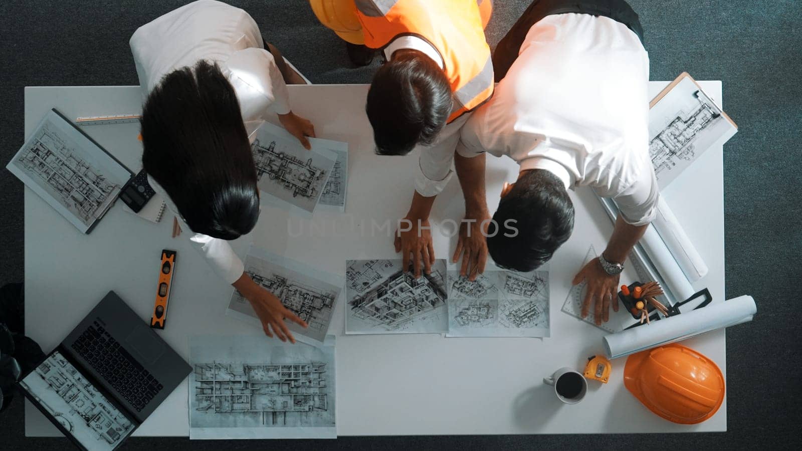 Top down view of project manager and civil engineer hold laptop while explain idea to architect. Aerial view of smart business team talking and brainstorming about building construction. Alimentation.