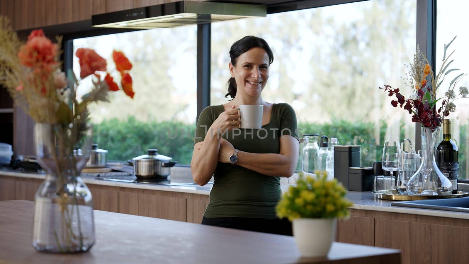 Happy old grandmother confidently standing pose while look at camera for good event or anniversary in kitchen. Cheerful senior enjoy retirement life with beautiful kitchenware and house. Divergence.